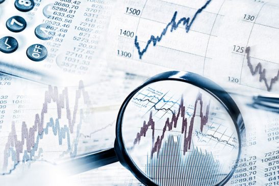 This image of a magnifying glass looking at the highs and lows of a financial chart represents stock market volatility that we have seen during the COVID-19 pandemic so far.