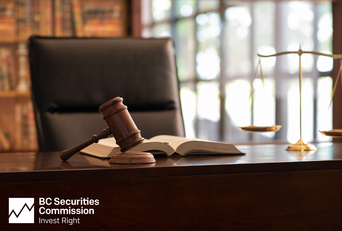 Wooden gavel atop a wooden desk with gold scales of justice representing BCSC's key focus of enforcement.